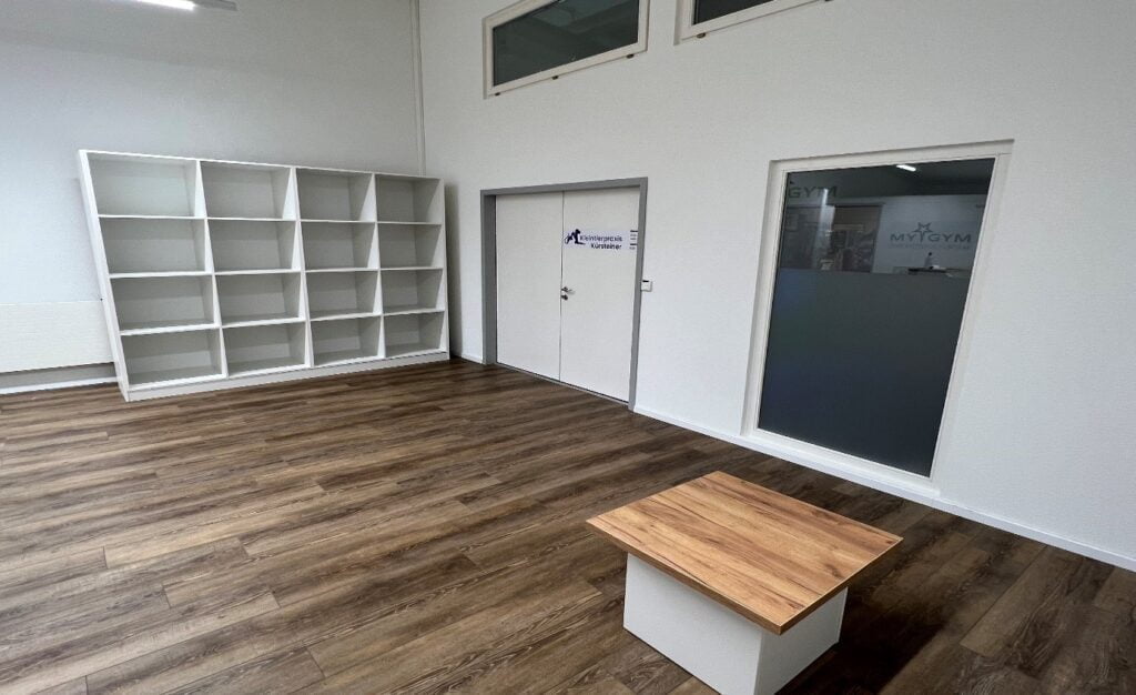 Eingangshalle der Kleintierpraxis Kürsteiner mit einem leerem Regal und einem kleinen Tisch